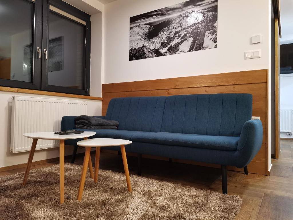 Obývacia časť apartmánu číslo 2 s pohovkou a fotografiou Tatier
